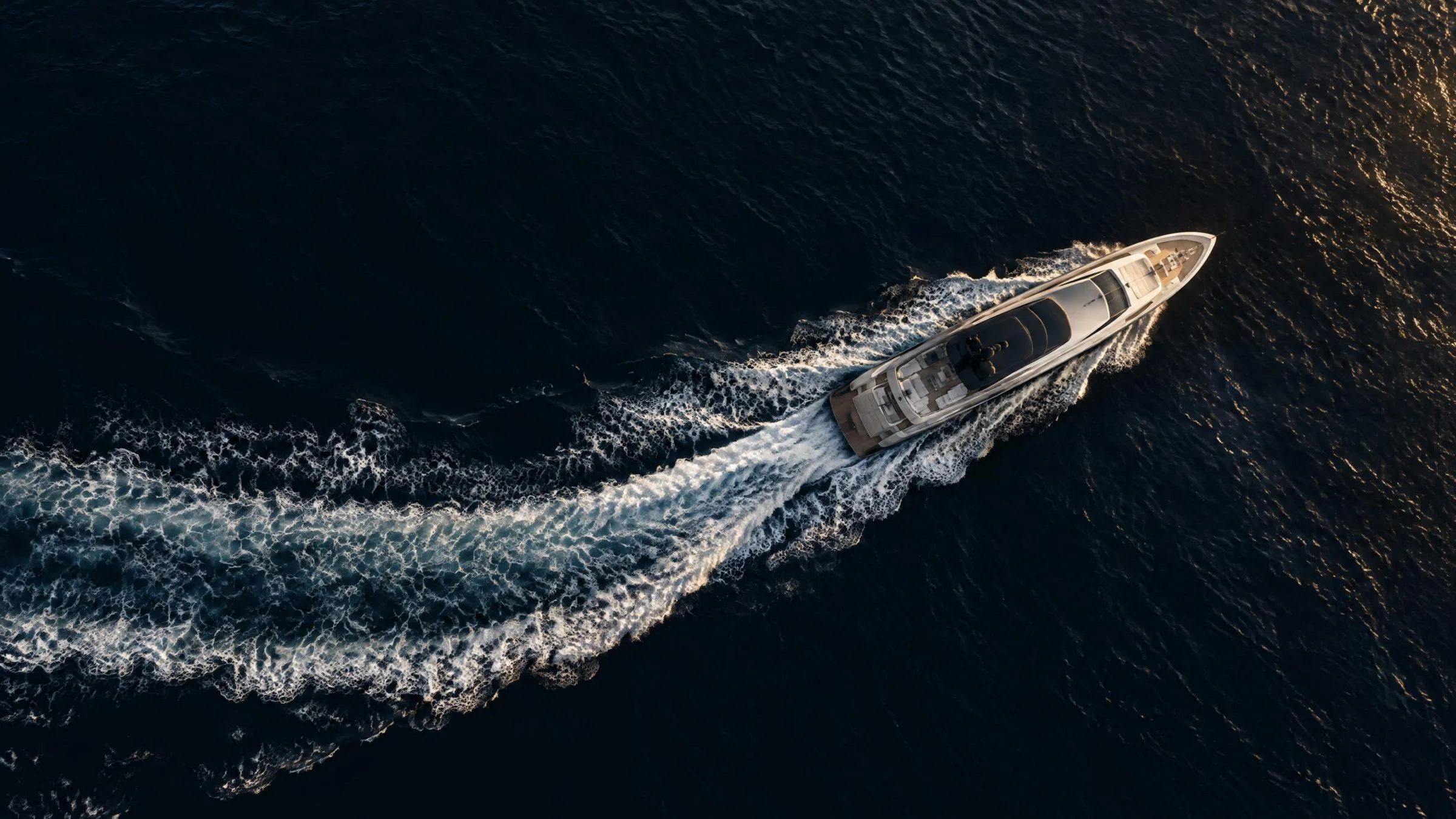 Aerial view of a superyacht cruising across dark open water