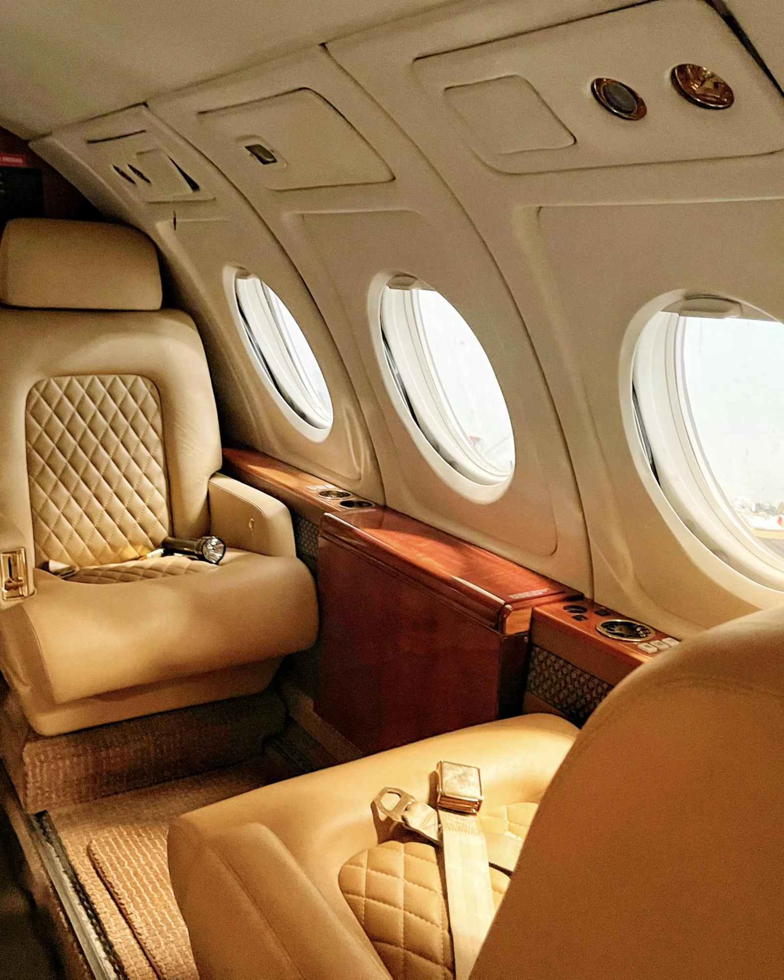 Tan quilted leather seats inside a private jet cabin