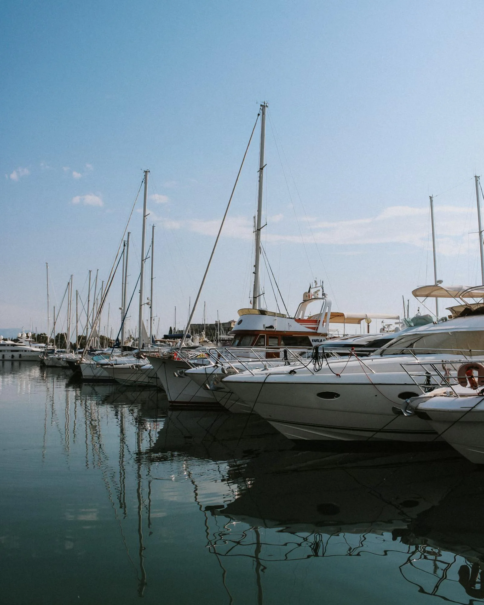Yachts moored in a marina on a clear day