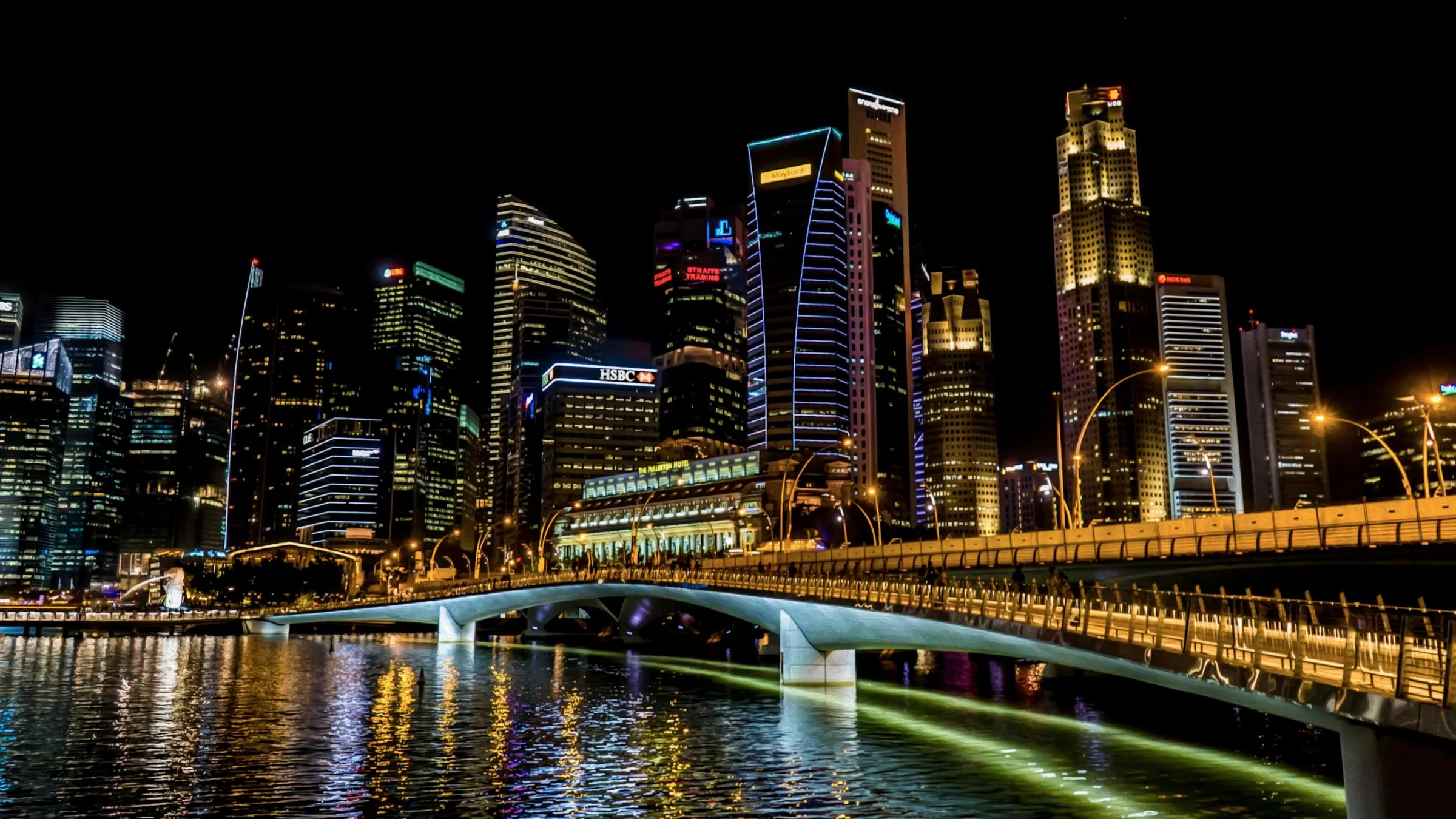 A city skyline at night reflected in the water